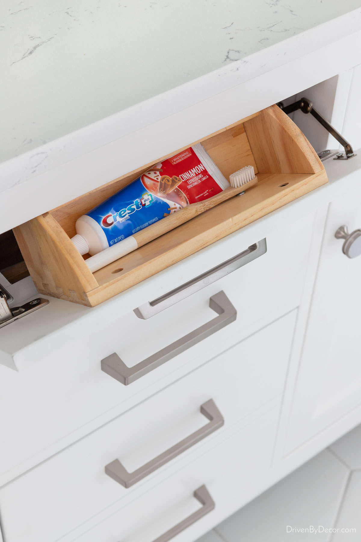 Tilt out tray in bathroom vanity with toothbrush and toothpaste