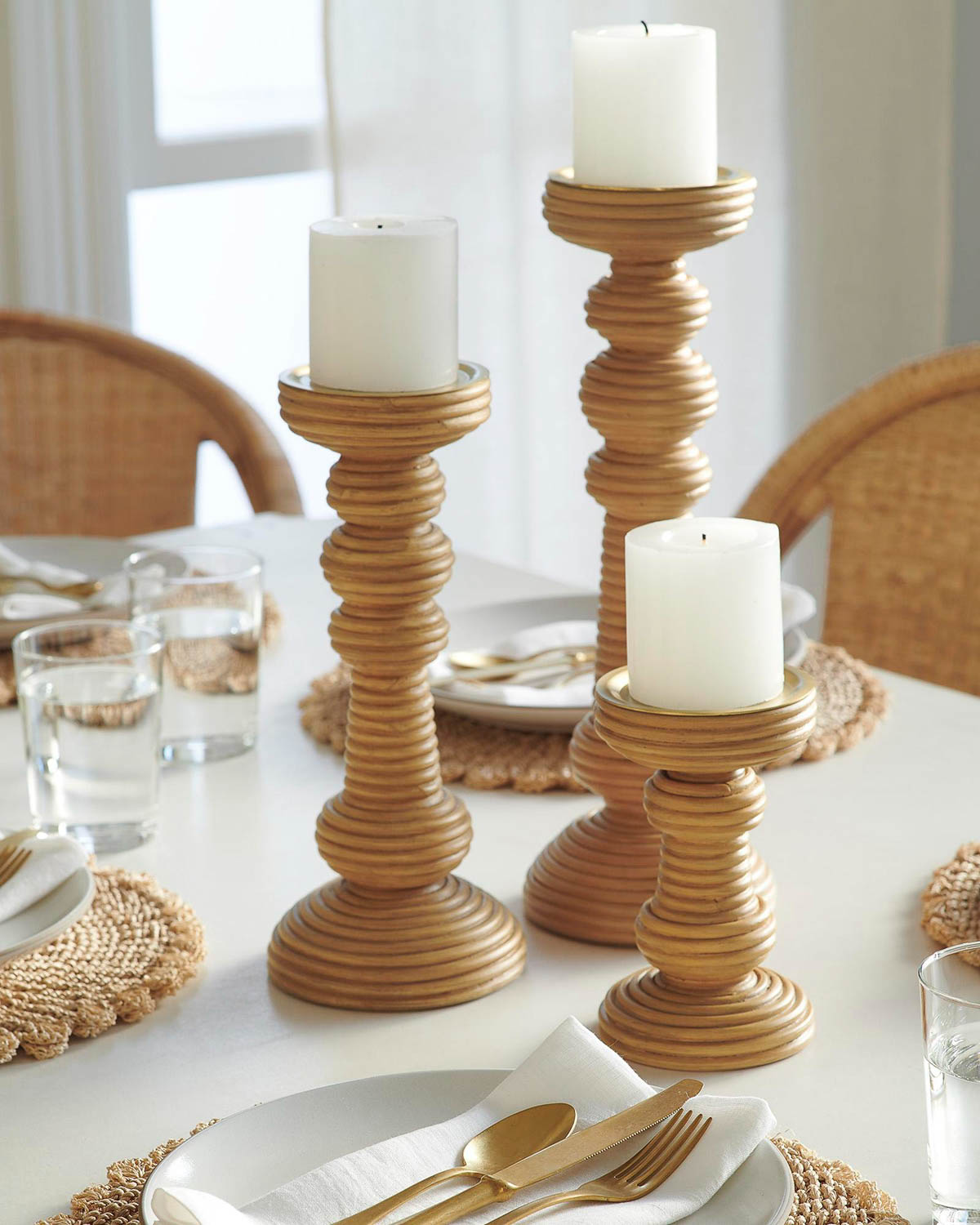 Group of three rattan candlesticks as a table centerpiece