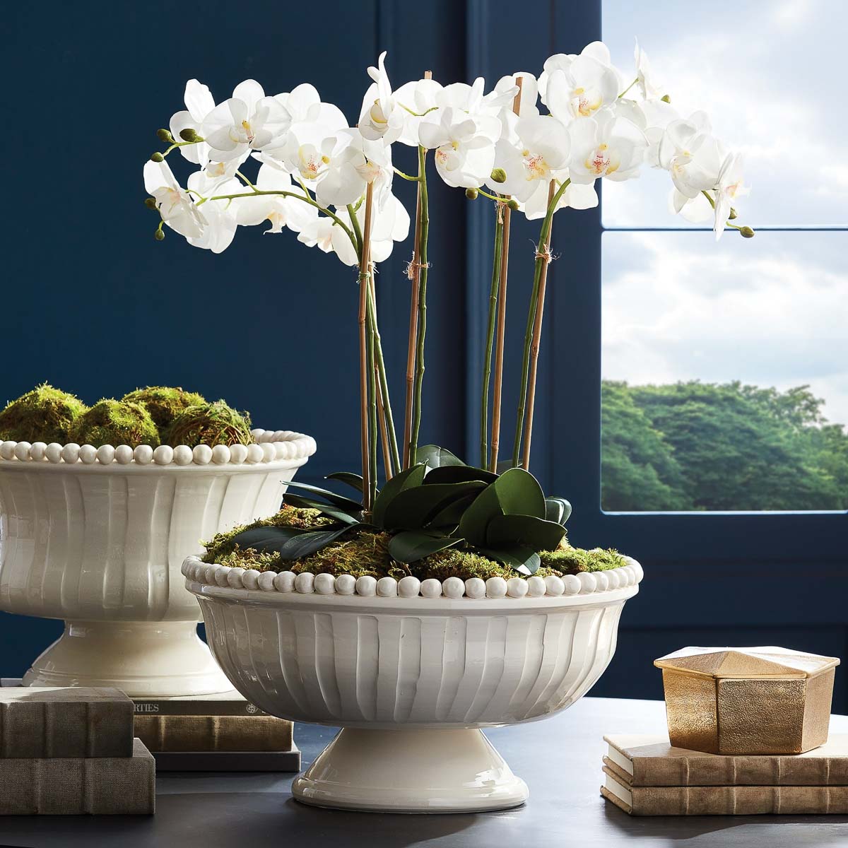 Dining table centerpiece of orchids in footed bowl
