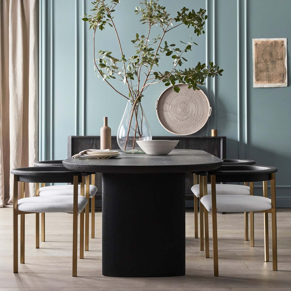 Vase with large greenery branches as dining table centerpiece