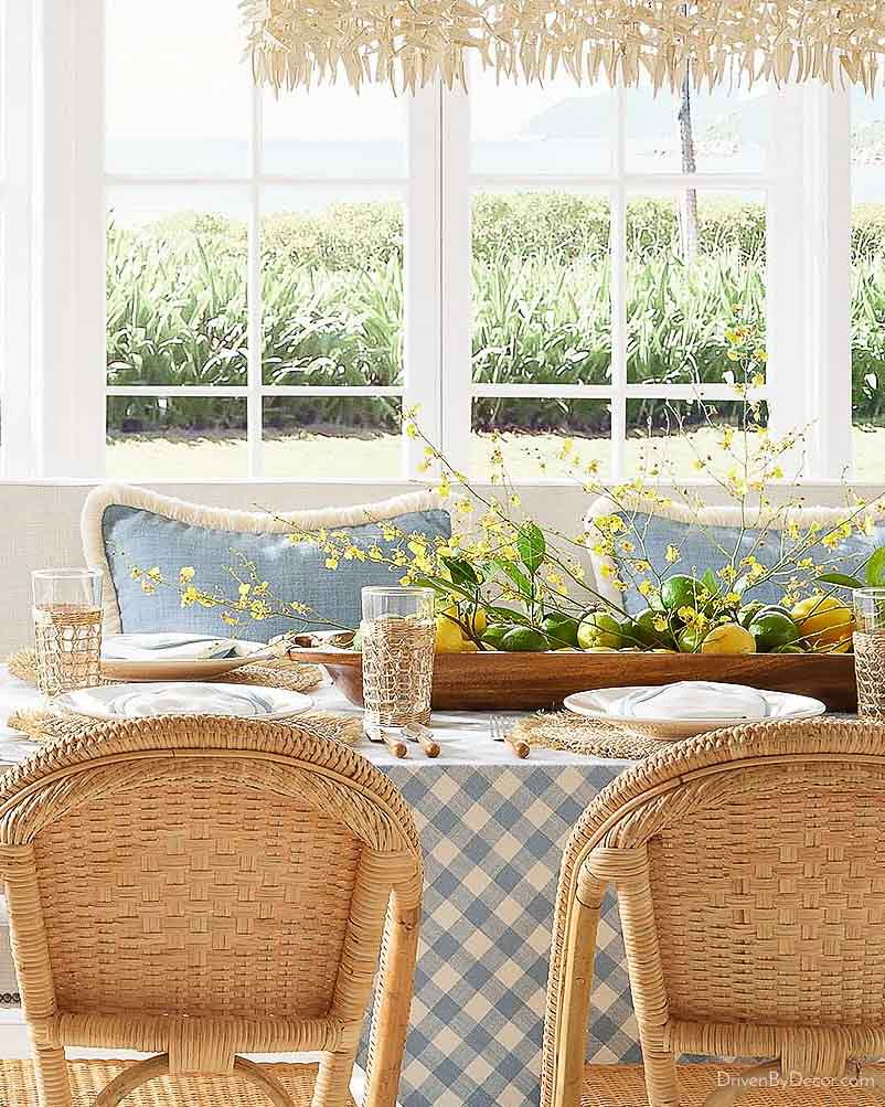 Lemons, limes, and forsythia branches in dough bowl as dining table centerpiece