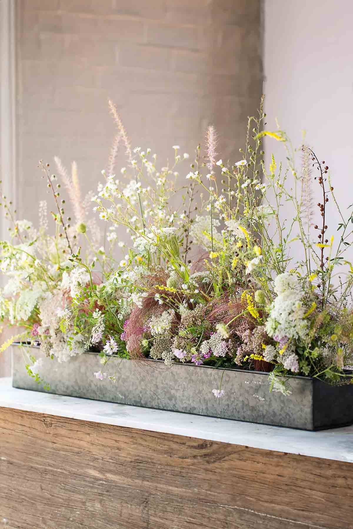 Silver trough filled with flowers as centerpiece