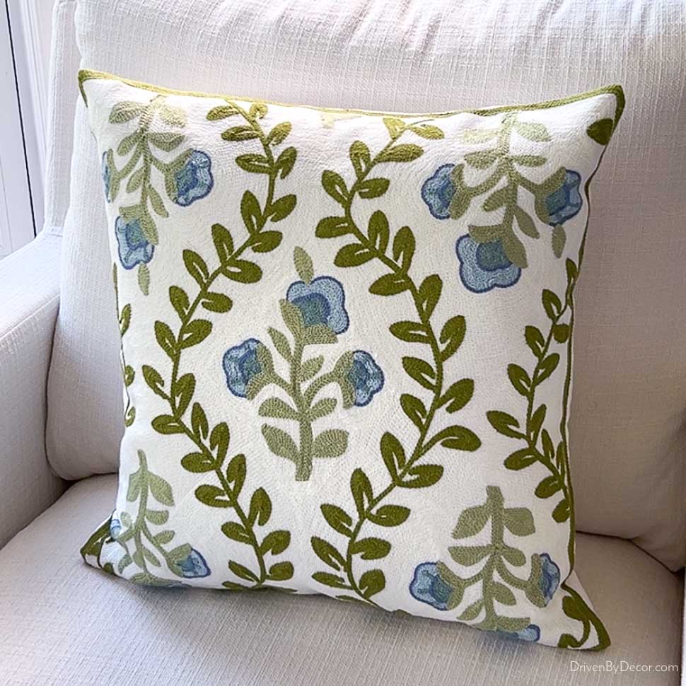 Budget throw pillow with blue floral and green vine embroidery