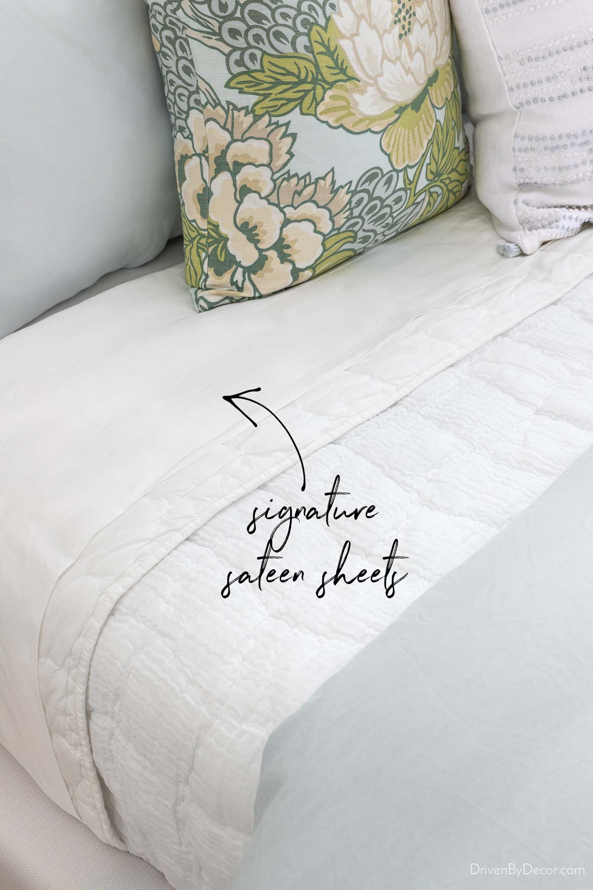 Multiple layers of bedding including Saatva's signature sateen sheets