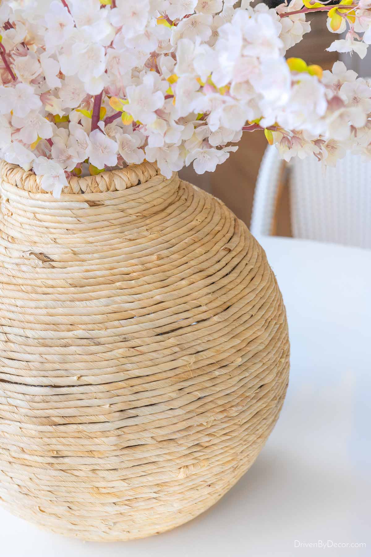Large seagrass wrapped vase filled with faux flowers
