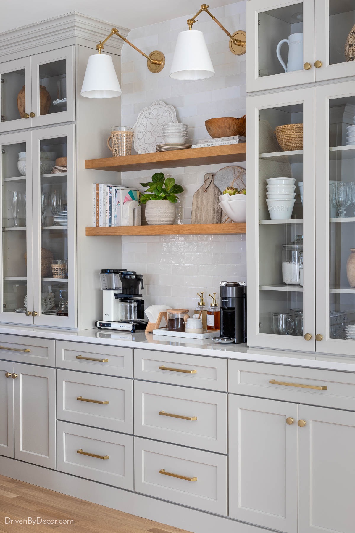 Kitchen coffee bar with glass doored upper cabinets resting on quartz topped base cabinets