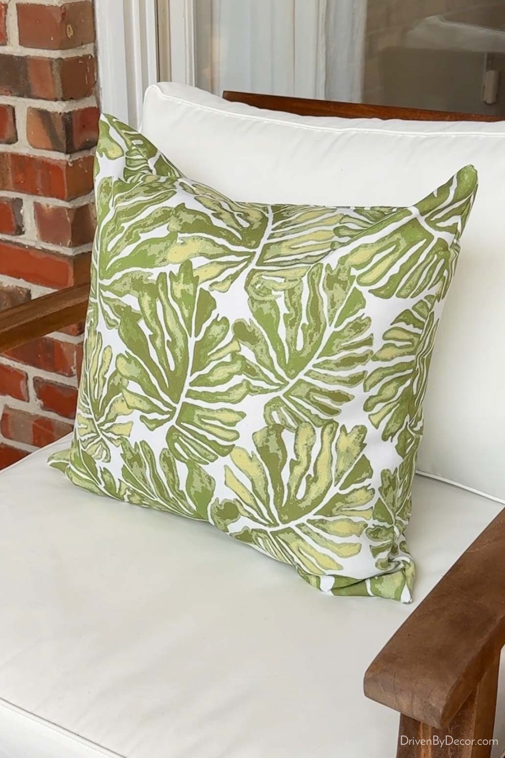 Green leaf outdoor pillow on chair
