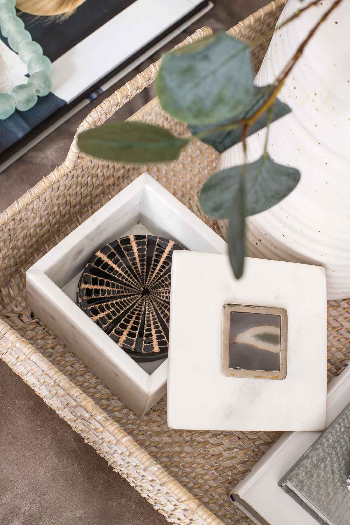 Coasters in a square marble box on a round coffee table