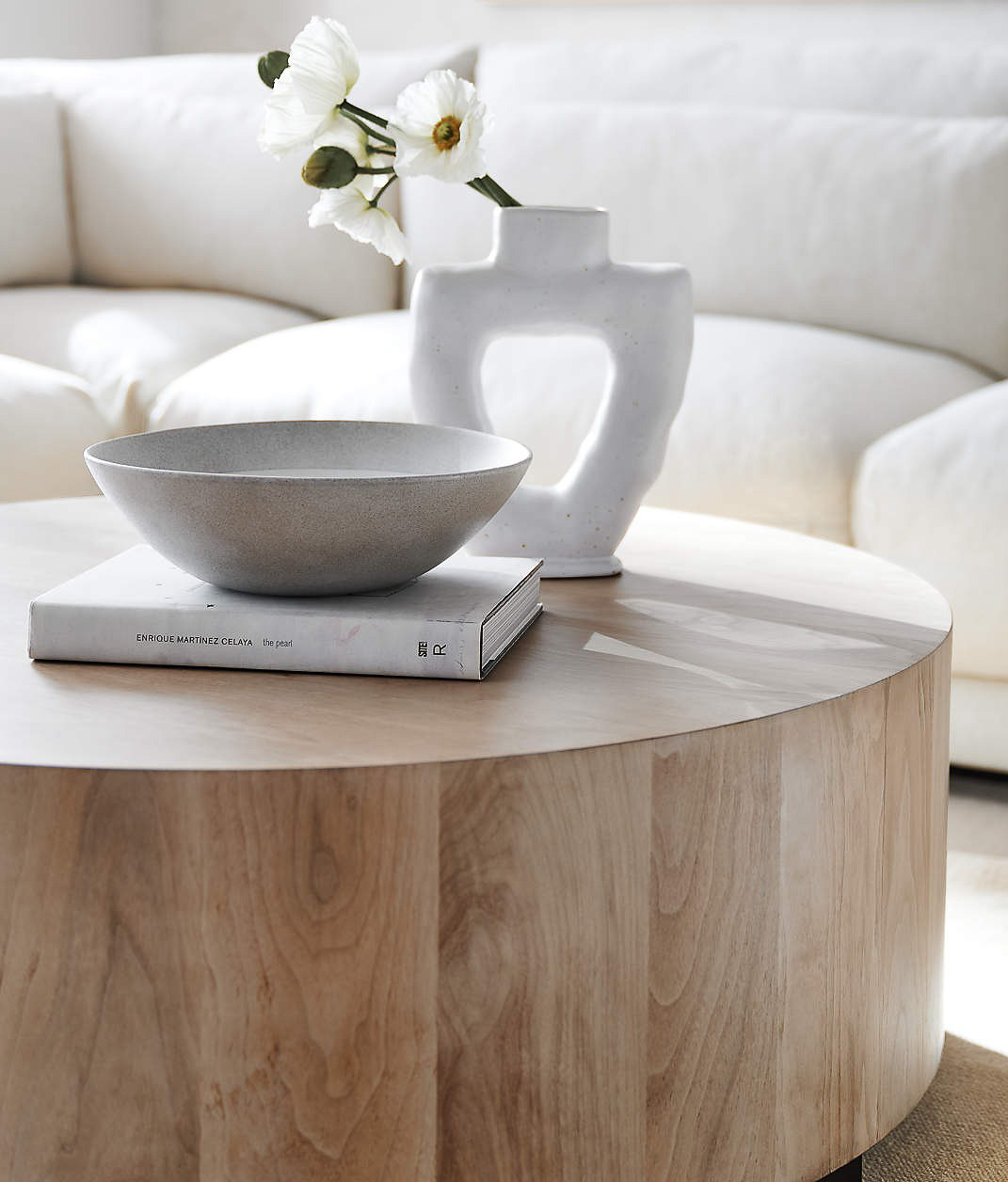 Round coffee table with book, bowl, and vase