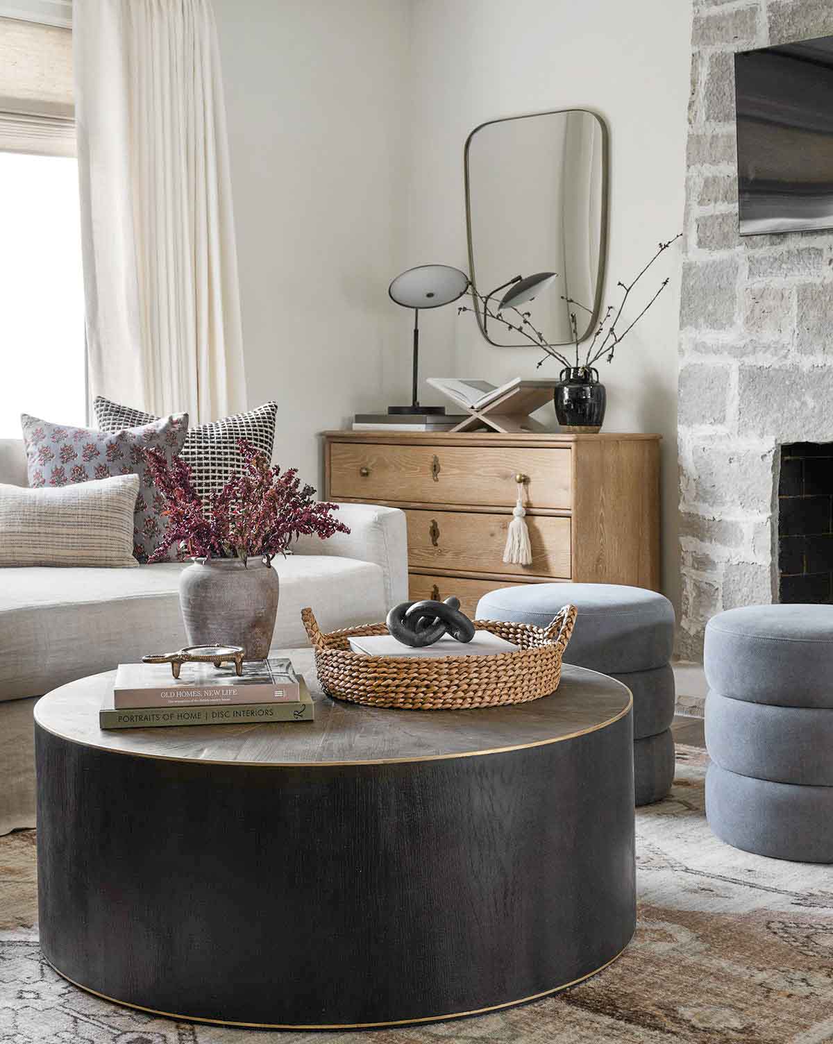Round coffee table with vase, round tray, and stack of books