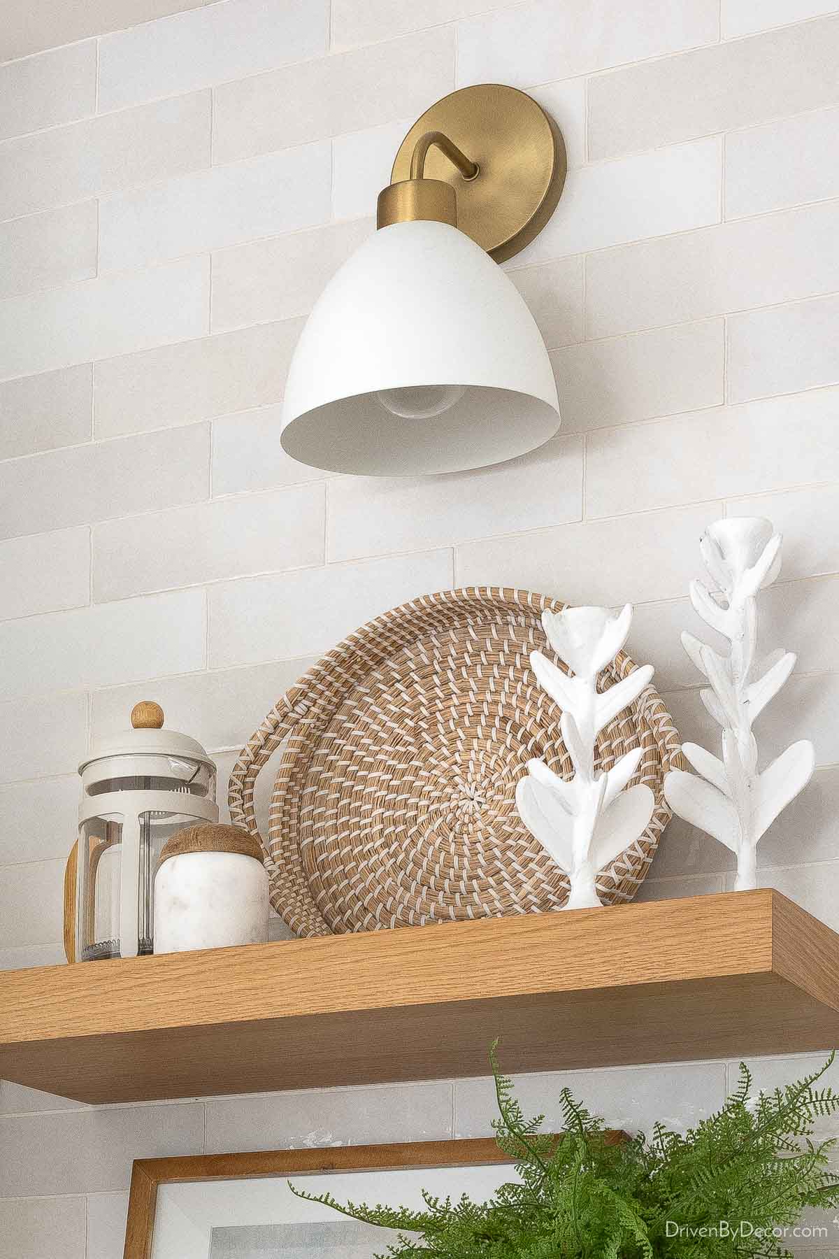 Sconce above floating shelf in kitchen