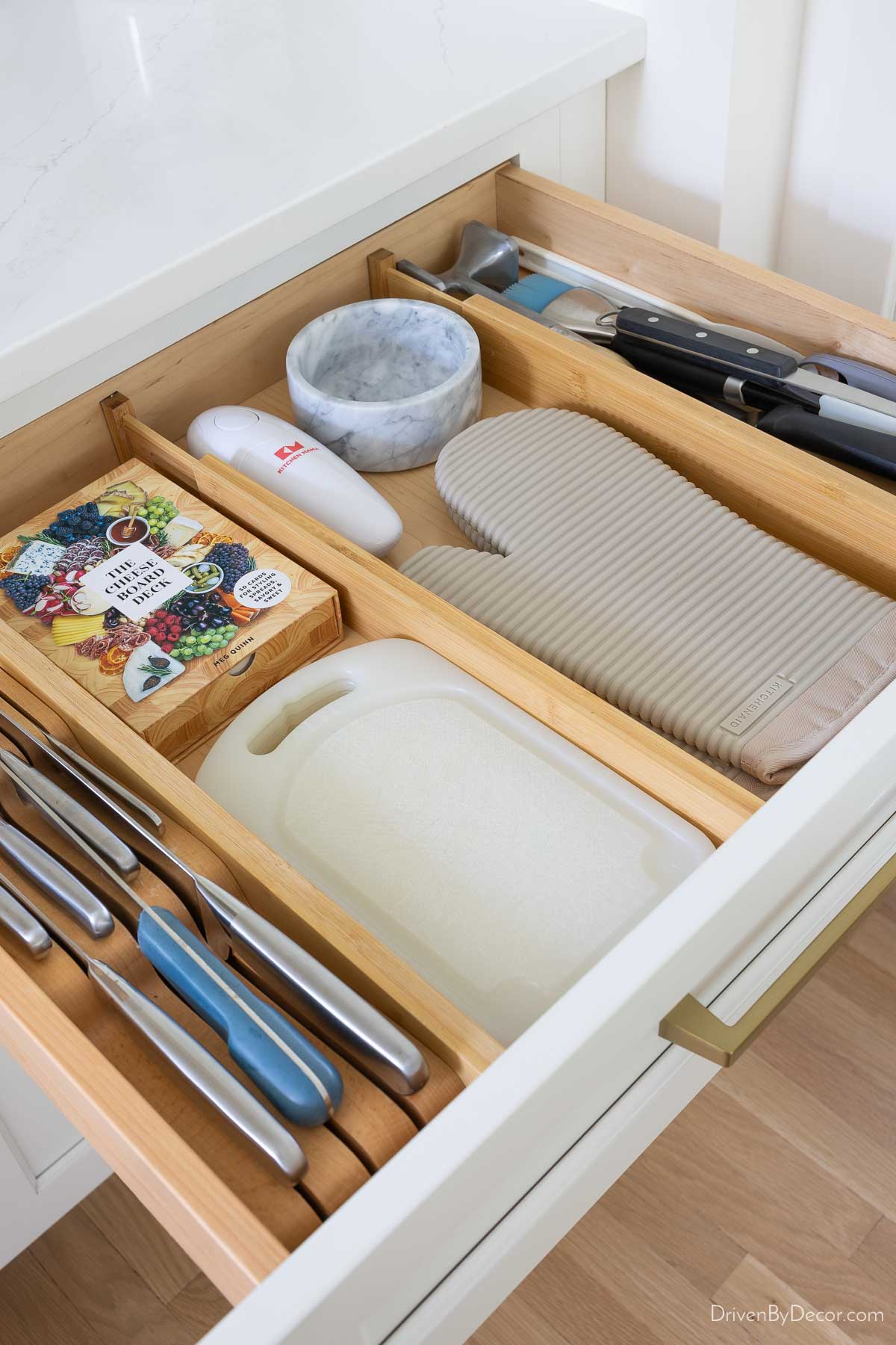 Kitchen drawer with knives, cutting boards, oven mitts, and utensils