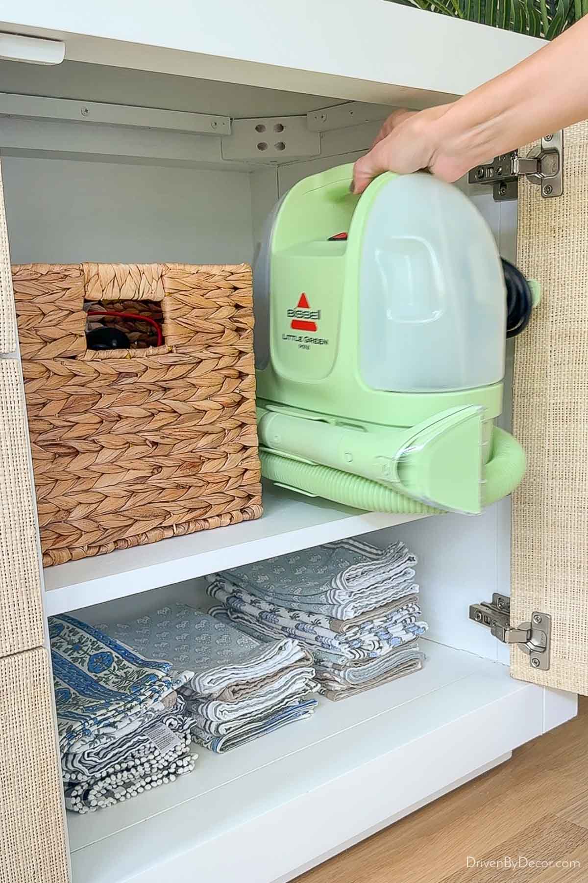 Putting Little Green Mini Carpet Cleaner in cabinet for storage