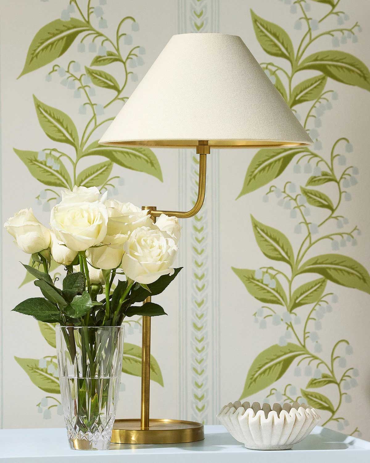 Small fluted marble bowl on table next to lamp and flowers
