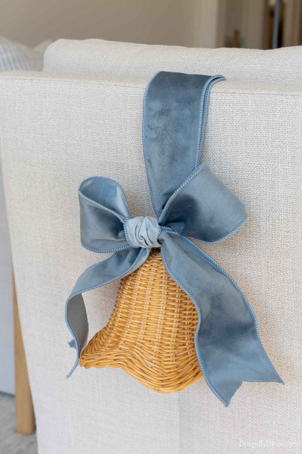 Rattan bells with velvet ribbon on back of chair for coastal Christmas decor