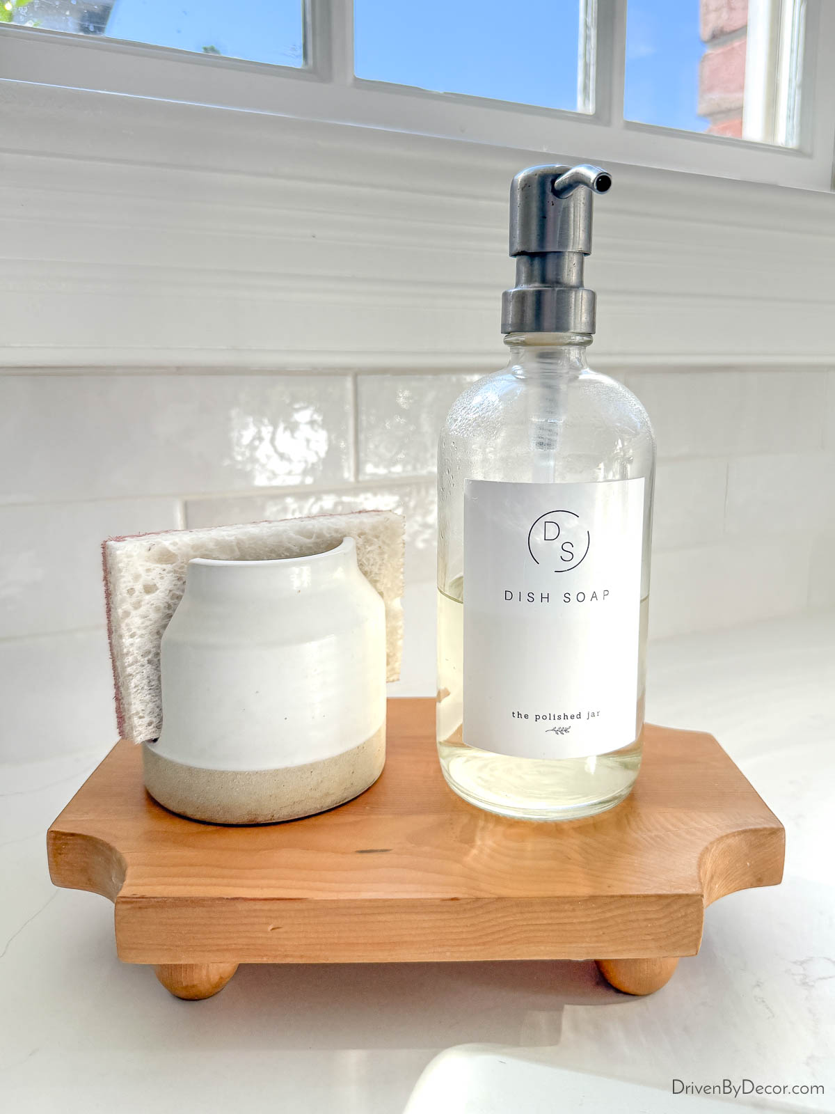 Ceramic sponge holder next to dish soap pump