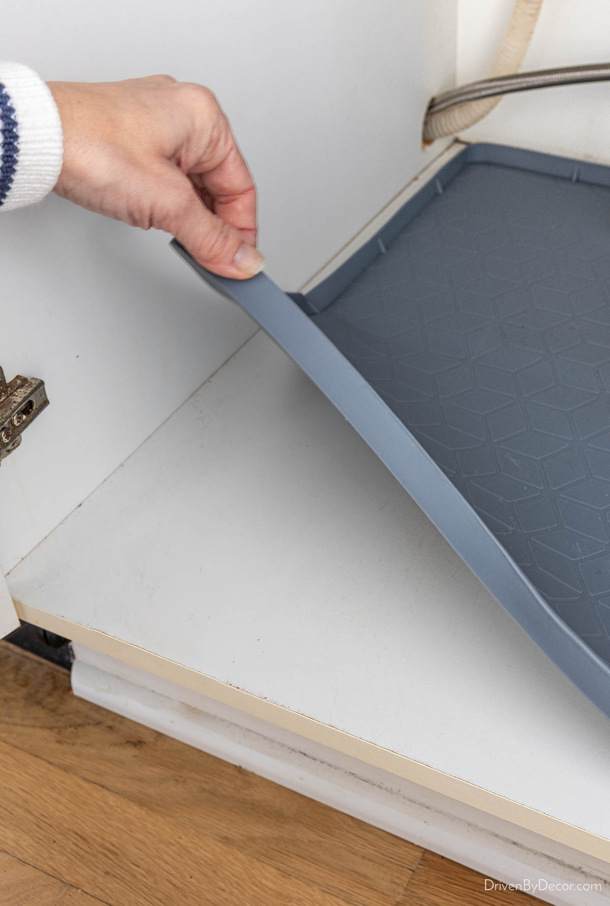 Gray silicone liner in kitchen sink cabinet