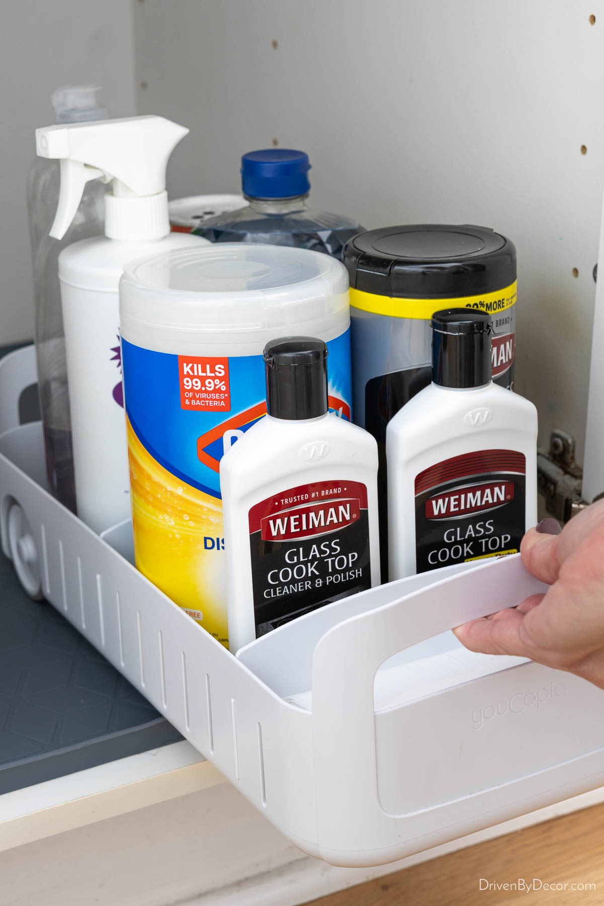 White rolling organizer filled with cleaning supplies