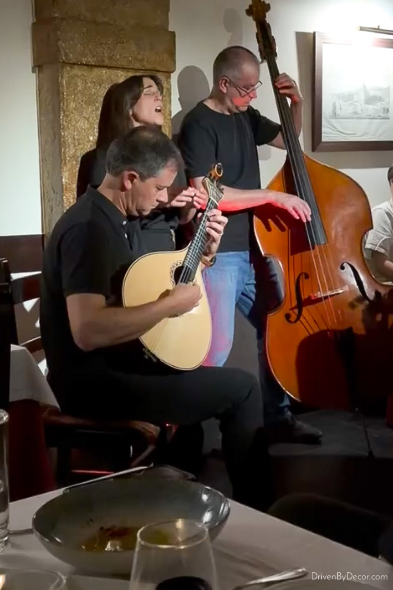 Woman vocalist and two men on string instruments performing Fado music