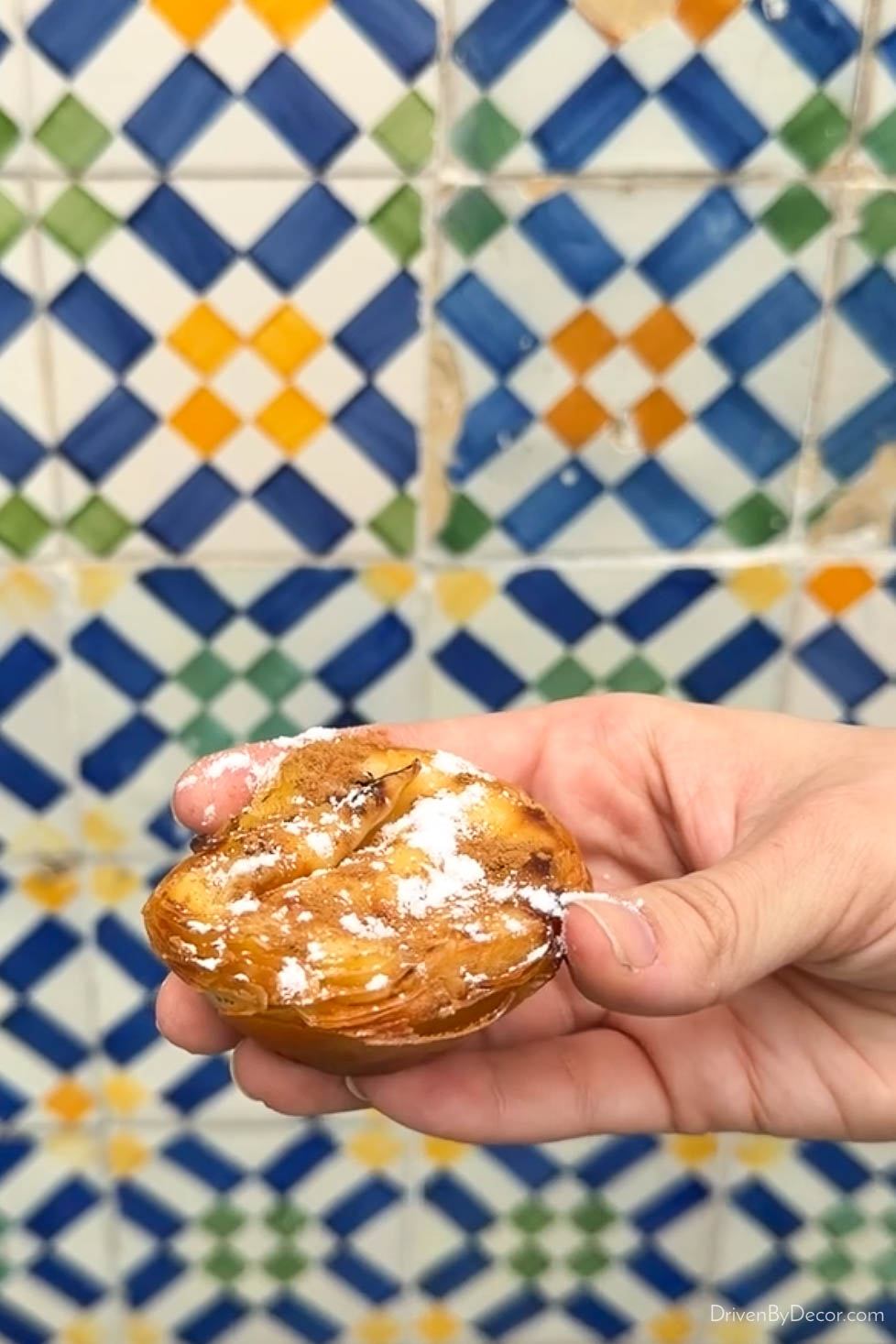Pastel de nata pastry in front of tiled wall