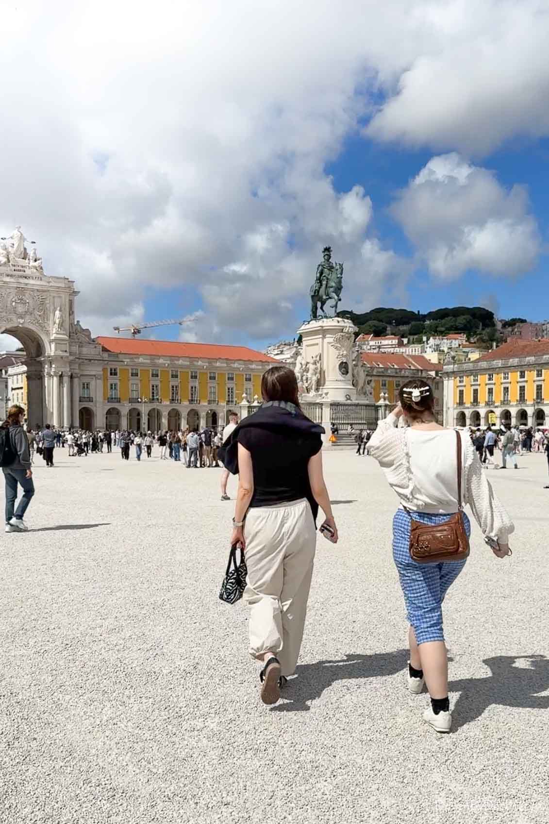 Two women strolling in Praca Do Comercio in Lisbon