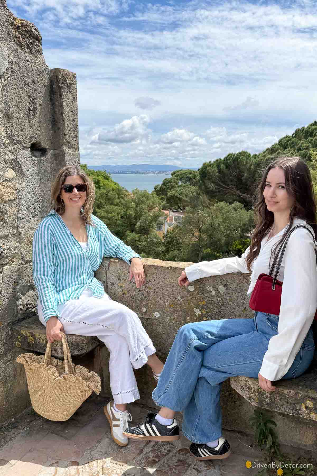 Two women sitting on benches at Sao Jorge Castle in Portugal