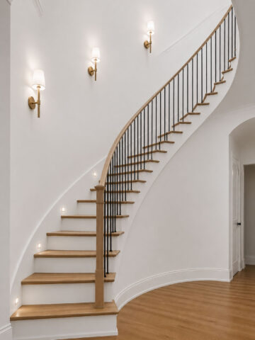 Curved staircase with lighting next to stairs