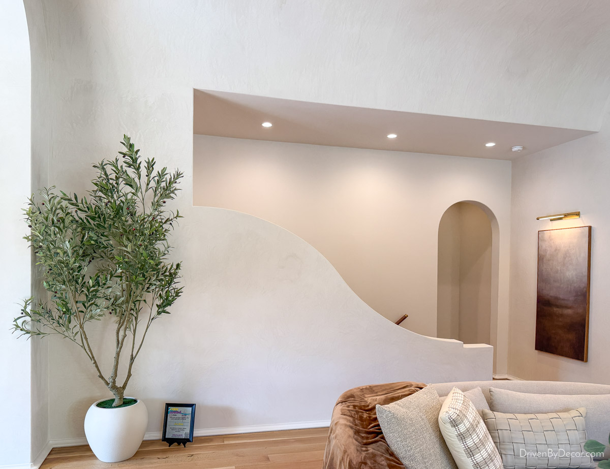Curved wall hiding entry into stairway to basement