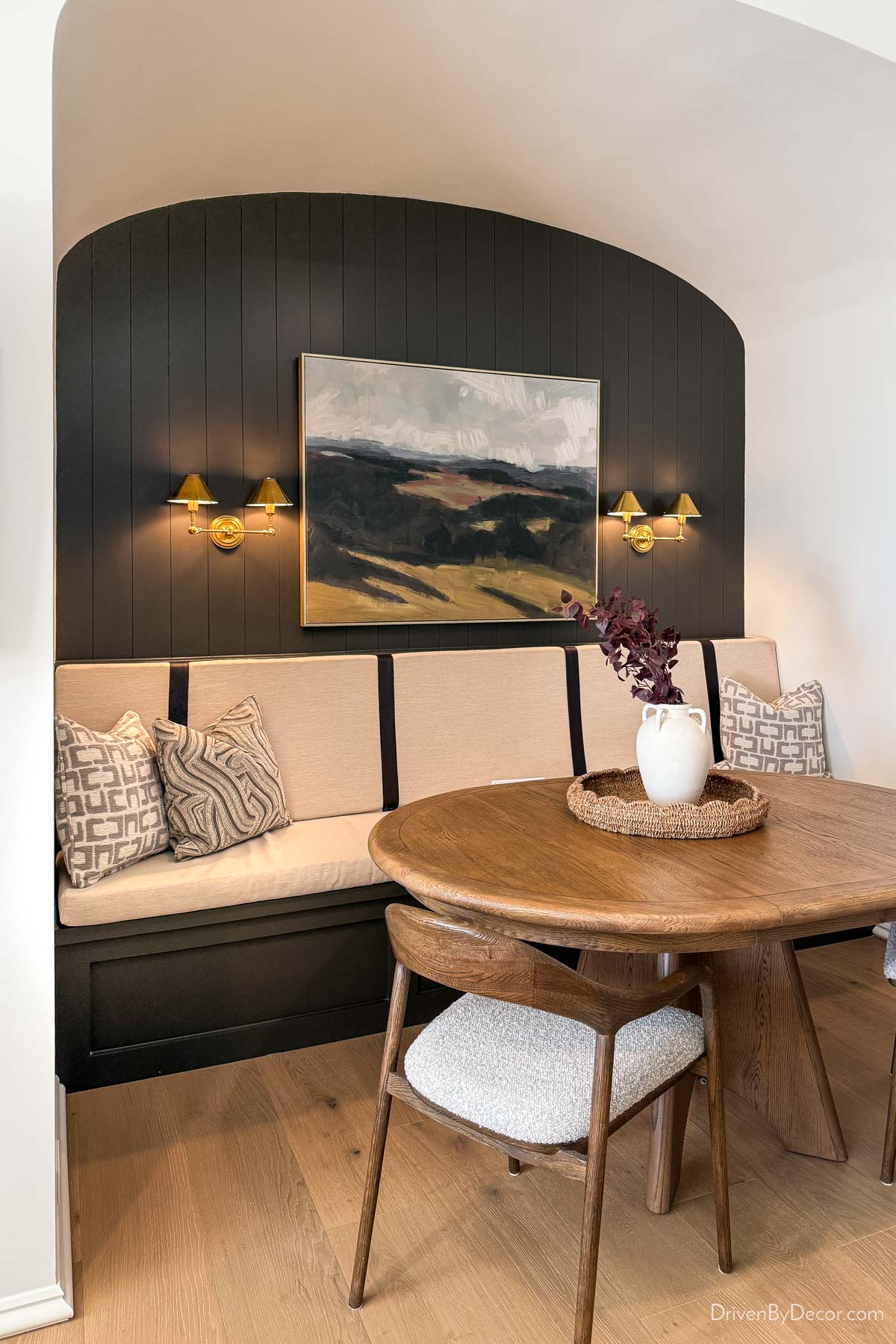 Cozy dining nook with bench and round table in arched opening
