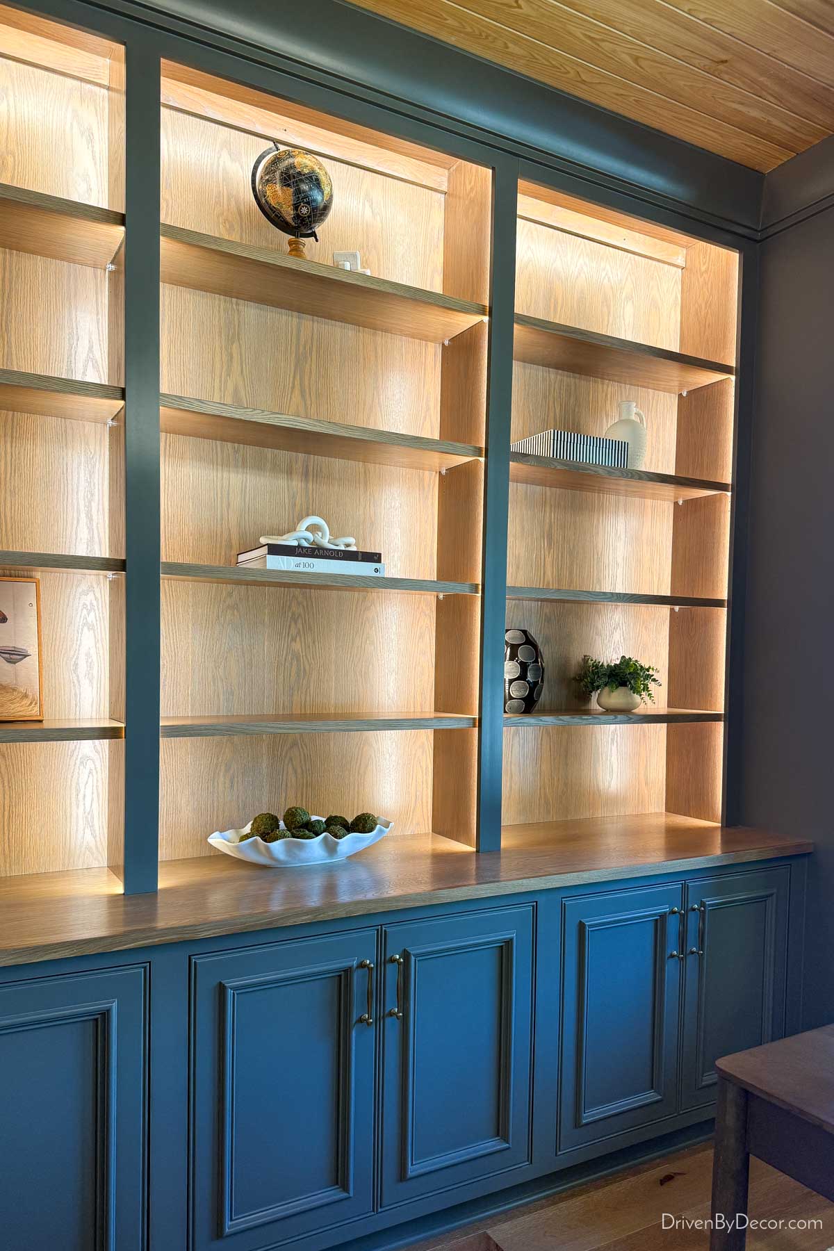 Cabinets with open bookshelves illuminated with recessed lighting