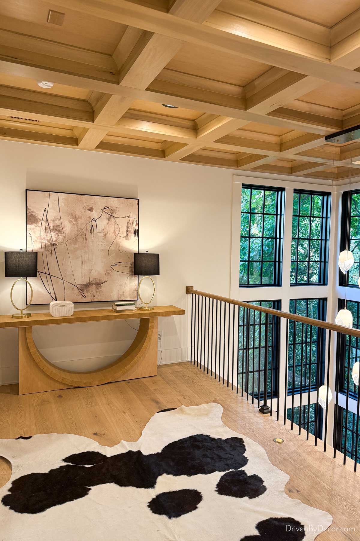 Upstairs landing with console, lamps, artwork, and cowhide rug