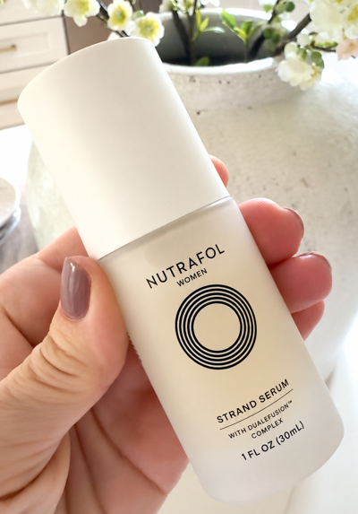 Hand holding Nutrafol Strand Serum
