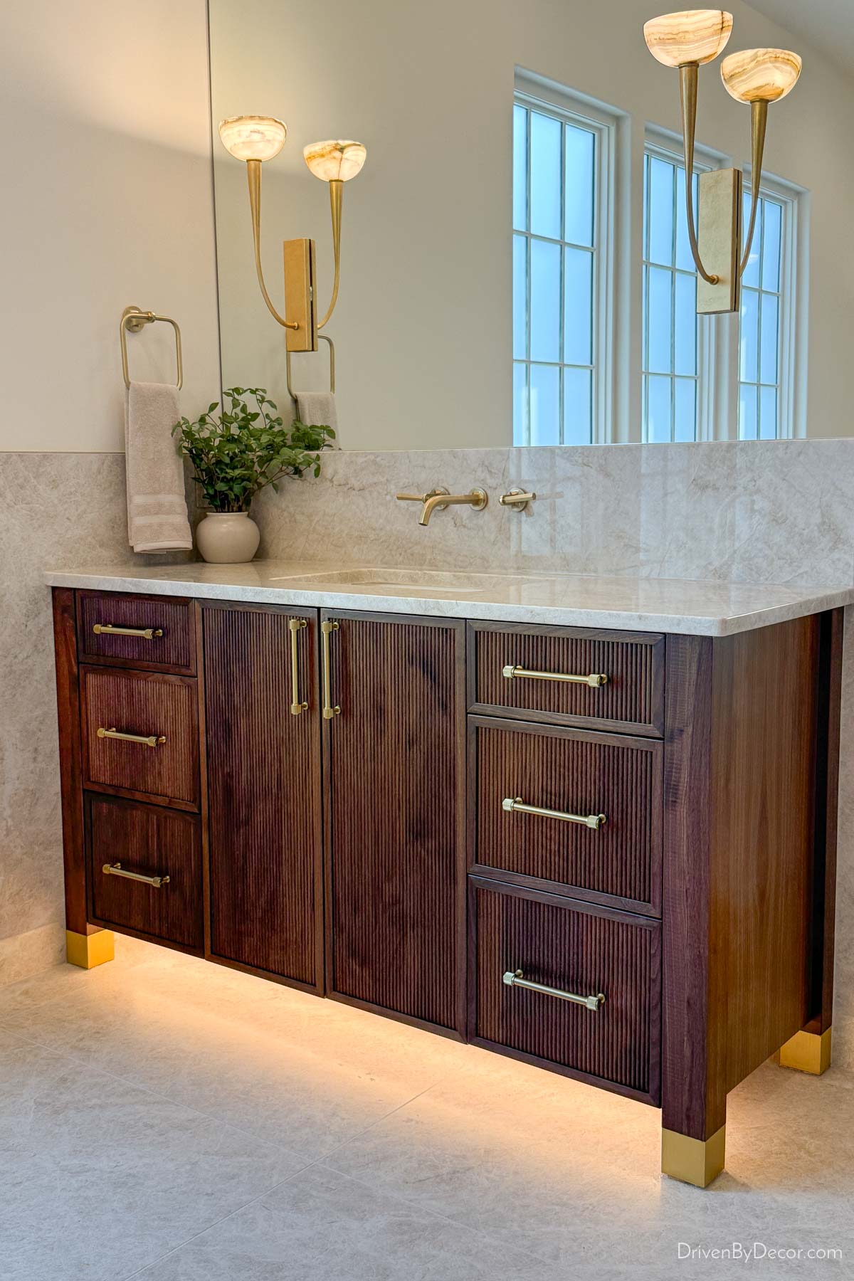 Dark wood bathroom vanity with toekick lighting